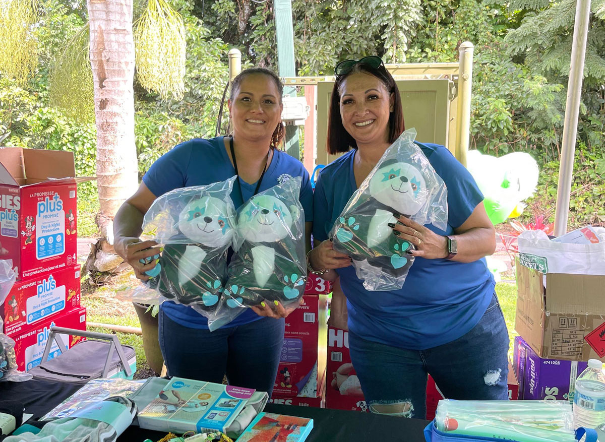 Hoʻoikaika-Partnership-Pandas-Partners-2-ladies-wering-blue-shirts-holding-panda-stuffed-animal